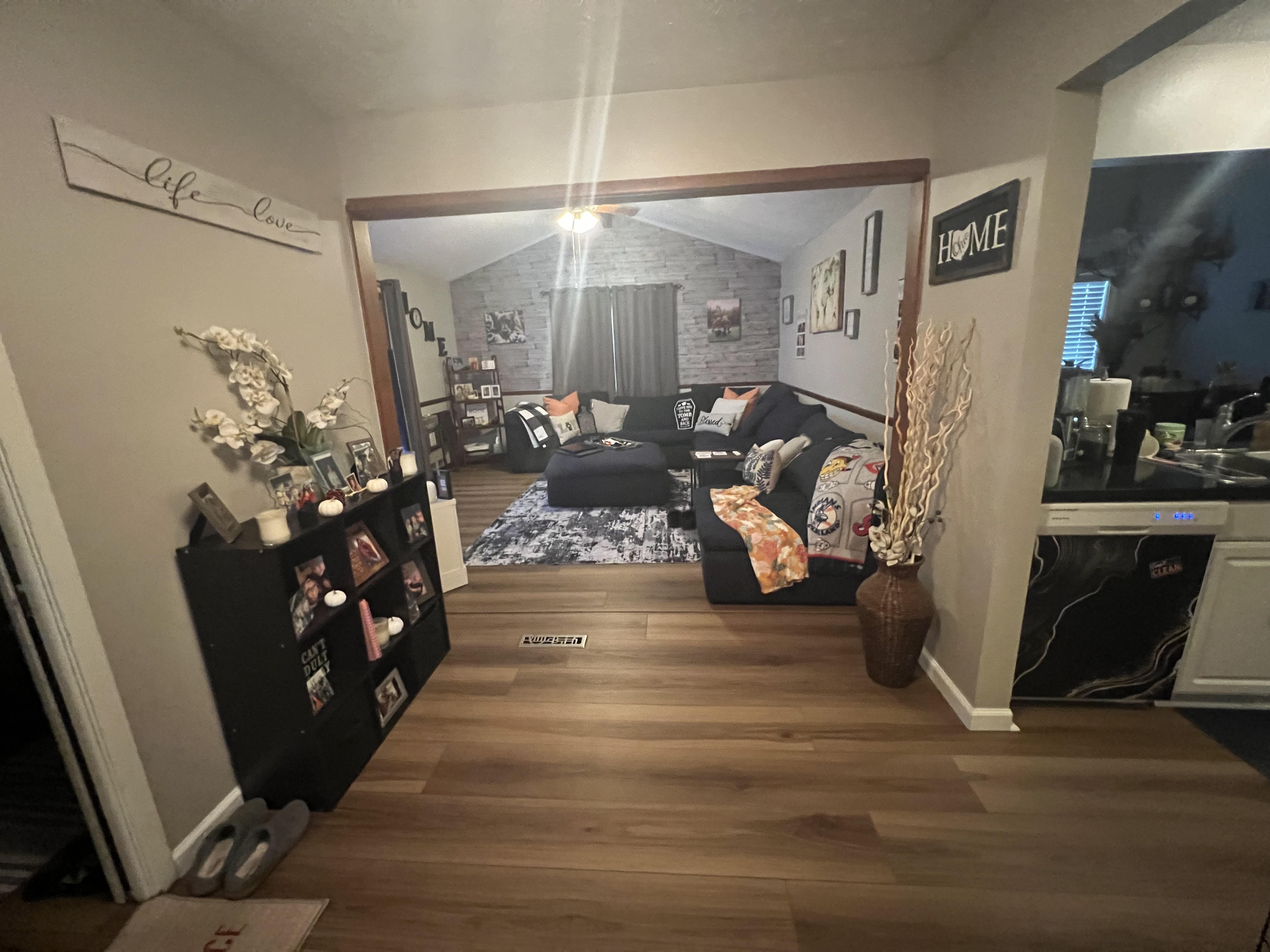 Warm honey-brown luxury vinyl plank flooring flowing from a hallway into a Strongsville family living room