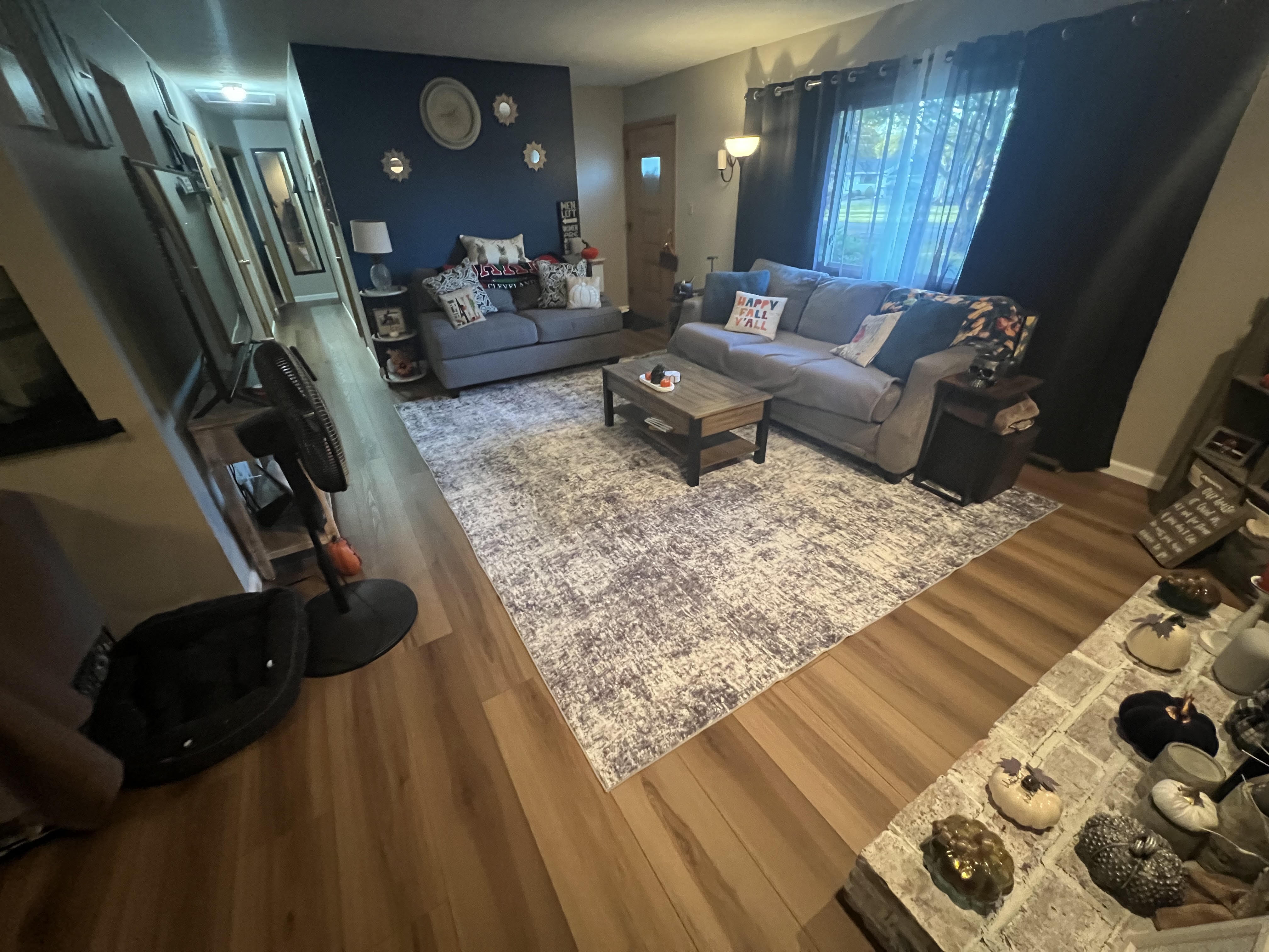 Light natural-tone luxury vinyl plank in a Strongsville living room with a navy accent wall
