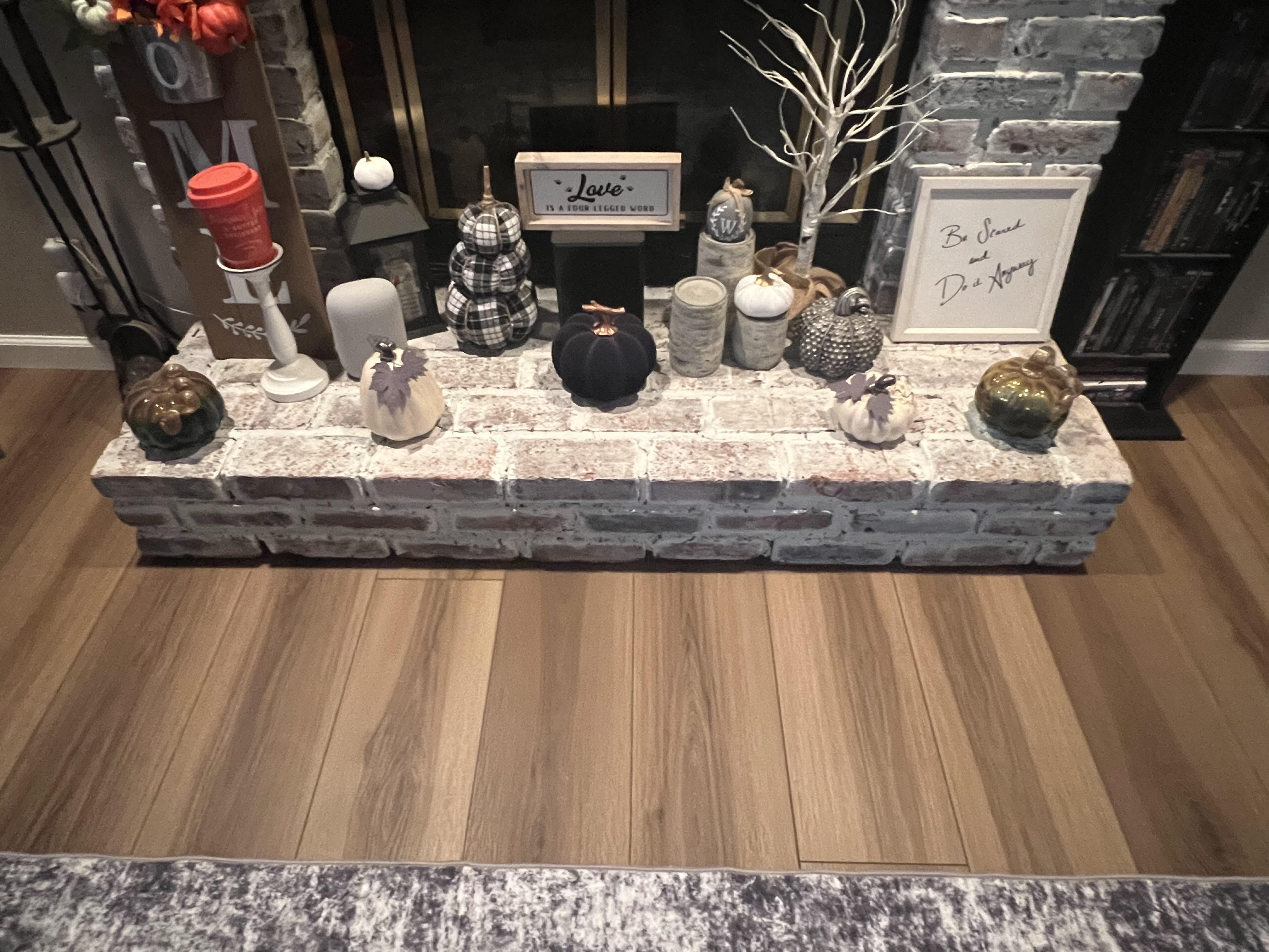 Luxury vinyl plank flooring in front of a brick fireplace hearth in a Strongsville home